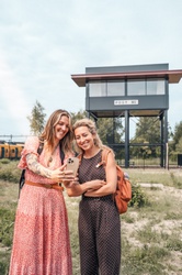 Twee vrouwen maken een selfie bij het treinstation