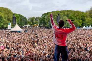 Een artiest houdt zijn vuist in de lucht en kijkt naar de menigte