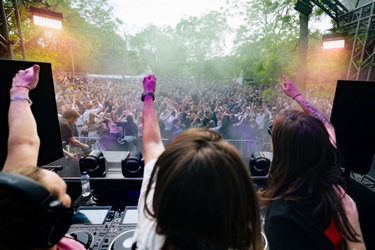 Drie DJ's steken een vuist uit naar het publiek