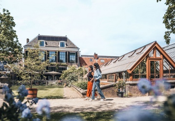Twee vrouwen lopen door de tuin van het Universiteitsmuseum Utrecht