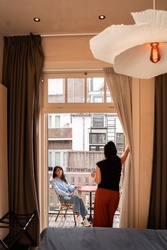 Een vrouw zit op het balkon in een hotel