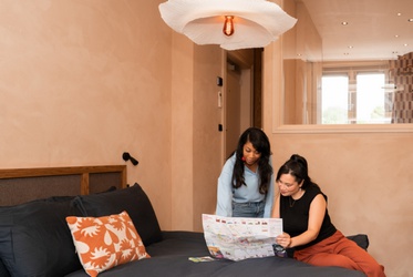 Twee vrouwen wijzen naar een kaart