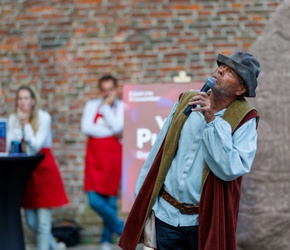 Een man met middeleeuwse outfit die naar boven kijkt