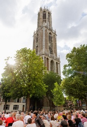 Een groep mensen die aan lange tafels zitten